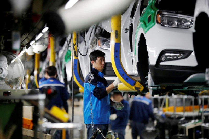 © Reuters. FILE PHOTO: Employees work at an assembly line of GM Korea's Bupyeong plant in Incheon