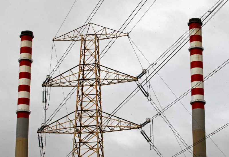 © Reuters. FILE PHOTO: Chimneys of the EDP Energias de Portugal power plant are seen behind the power cables in Sines