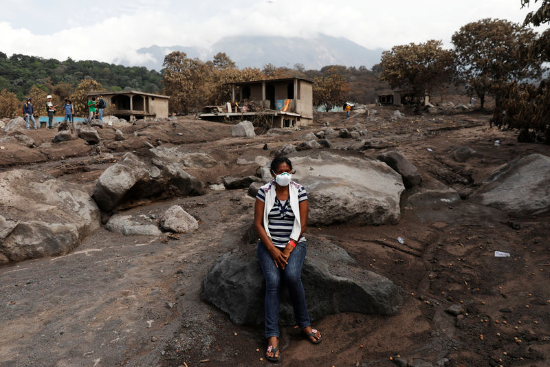 © Reuters. Eufemia Garcia, 48, who lost 50 members of her family during the eruption of the Fuego volcano, sits on a rock on top what use to be her family house in San Miguel Los Lotes