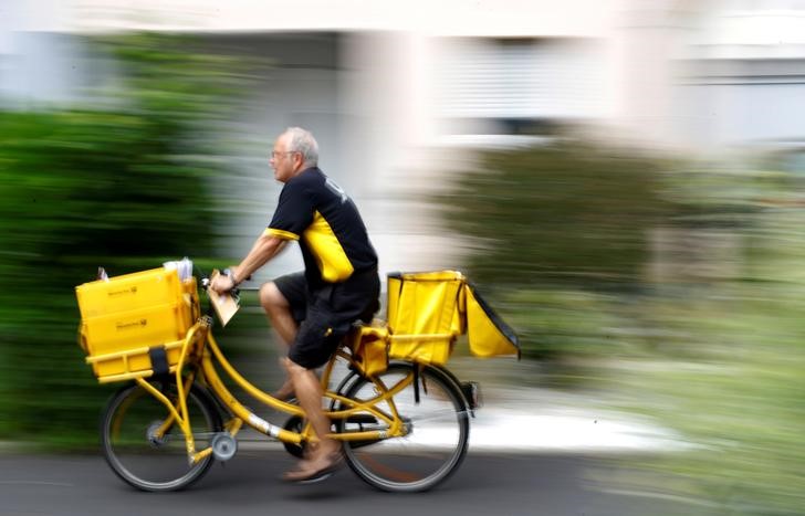 © Reuters. FILE PHOTO: A postman of German mail services Deutsche Post AG rides his delivery bicycle in Hanau