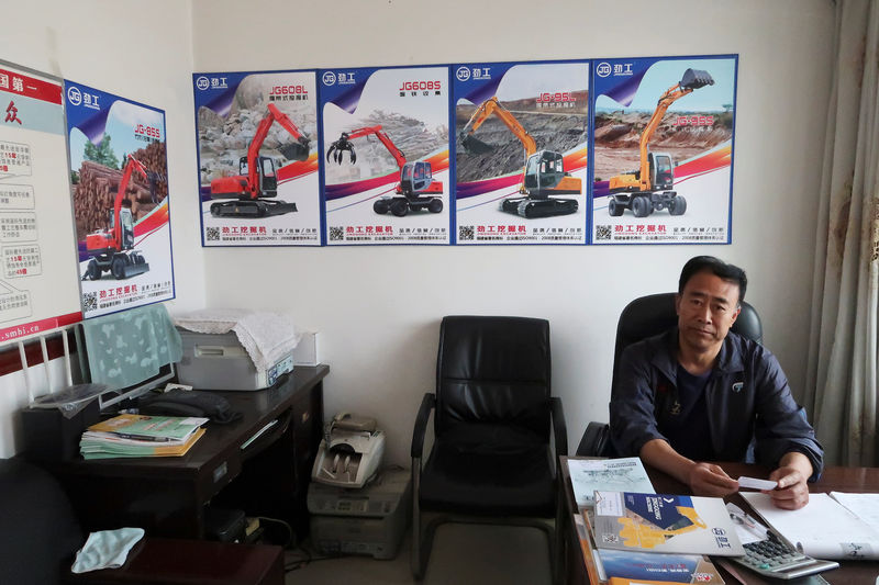© Reuters. Wang Chenglin, who runs a construction machinery distributor, poses for a picture at his office in Dandong