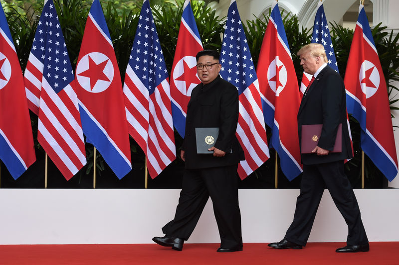 © Reuters. U.S. President Donald Trump and North Korea's leader Kim Jong Un react during their summit at the Capella Hotel on Sentosa island in Singapore