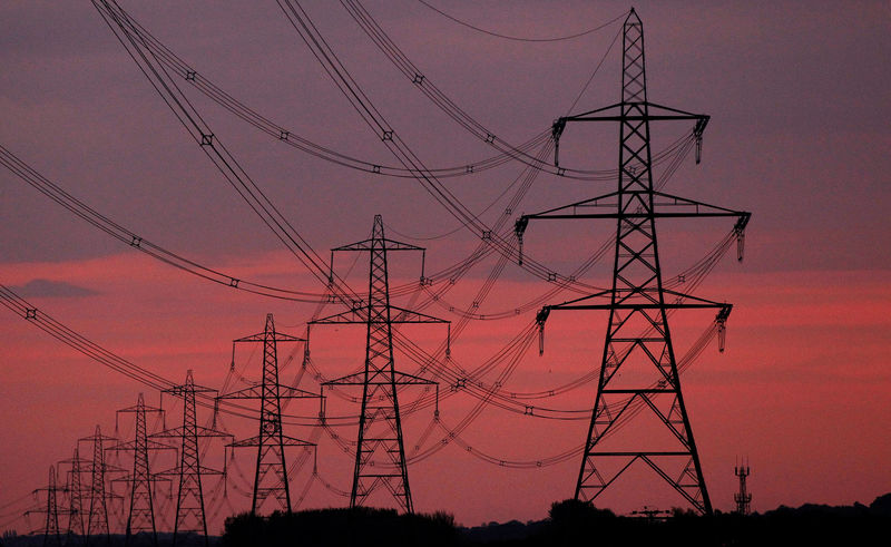 © Reuters. FILE PHOTO: The sun rises behind electricity pylons near Chester