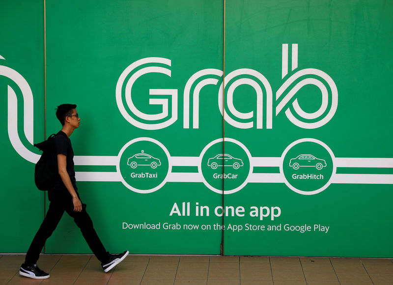 © Reuters. FILE PHOTO: A man walks past a Grab office in Singapore