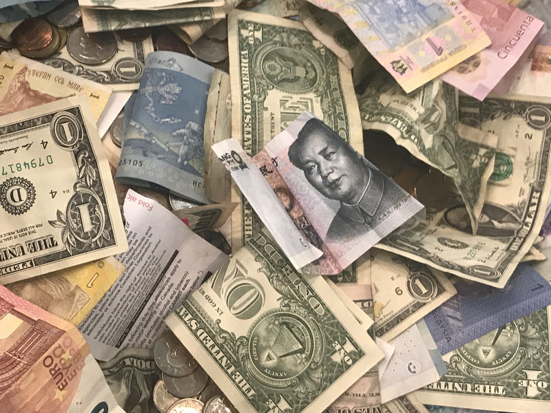 © Reuters. U.S. dollars and other world currencies lie in a charity receptacle at Pearson international airport in Toronto