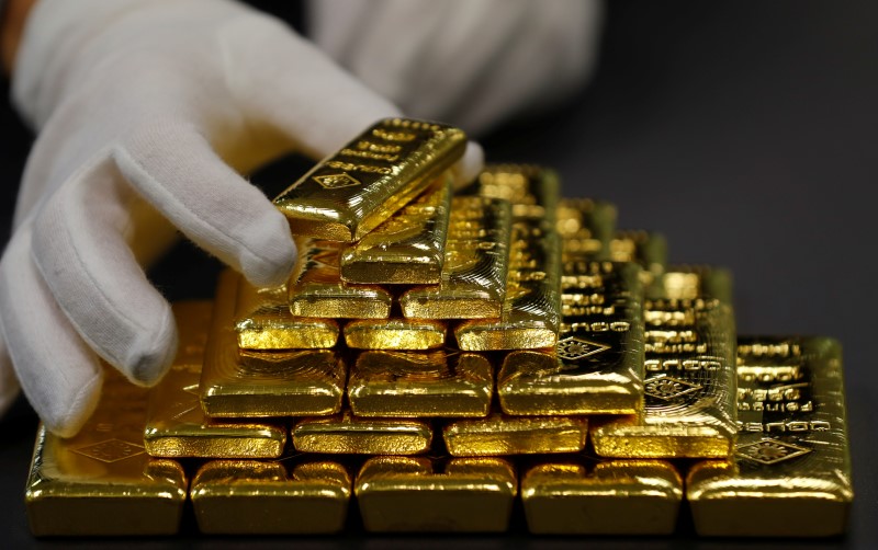 © Reuters. Сотрудник выкладывает золотые слитки на заводе Oegussa в Вене