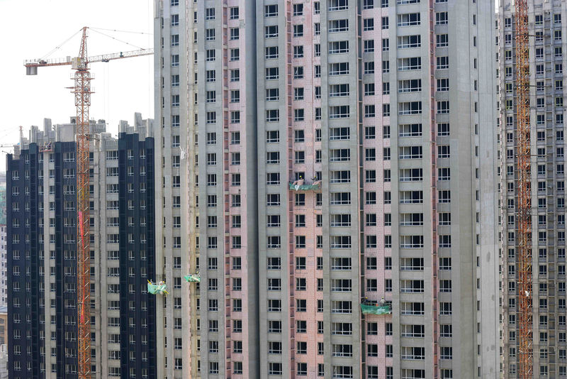 © Reuters. Workers are seen at a construction site of residential buildings in Qingzhou