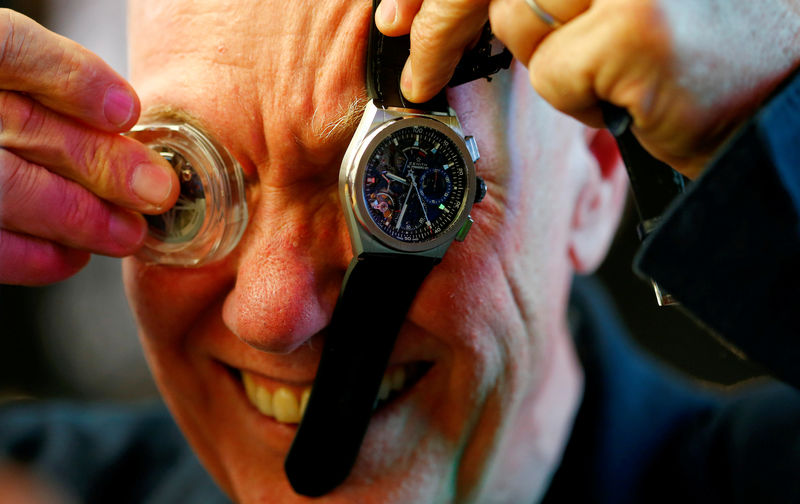 © Reuters. FILE PHOTO: Jean-Claude Biver, Tag Heuer CEO and President of LVMH Watch Division poses with a watch movement and a Zenith El Primero 21 watch  at the Baselworld watch and jewellery fair in Basel
