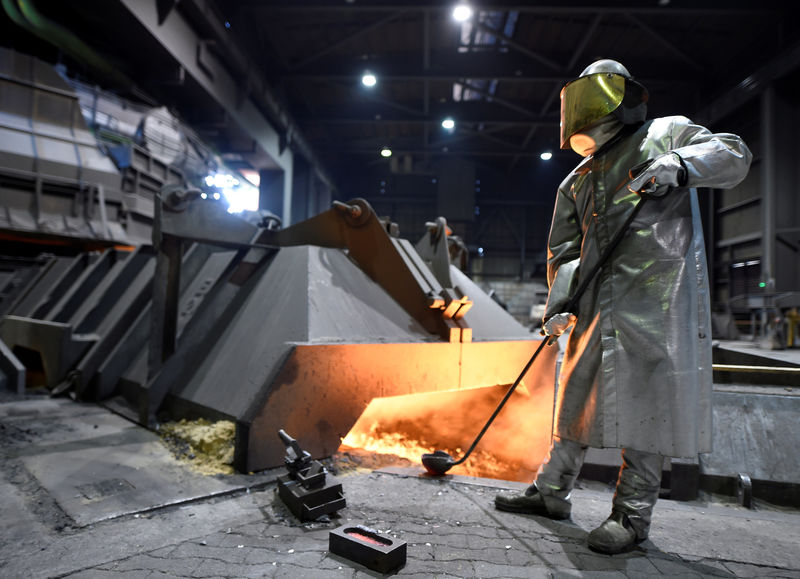 © Reuters. FILE PHOTO: A worker at German steel manufacturer Salzgitter AG stands in front of a furnace at a plant in Salzgitter