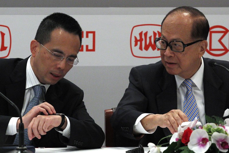 © Reuters. Hutchison Whampoa Chairman Li Ka-shing listens to his son Victor during a news conference announcing Hutchison Whampoa Ltd's interim results in Hong Kong