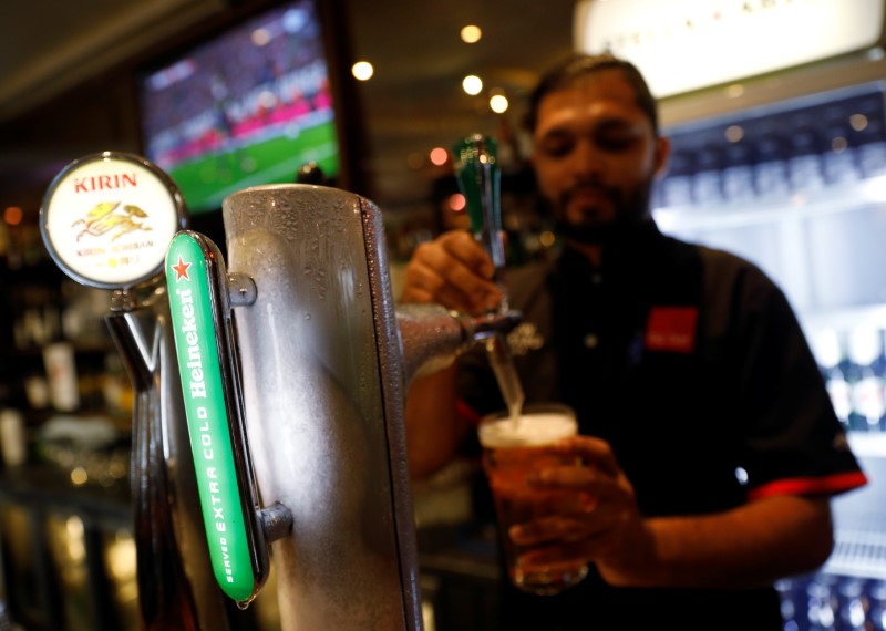 © Reuters. A bartender serves Heineken beer at a pub that shows football matches at Boat Quay in Singapore