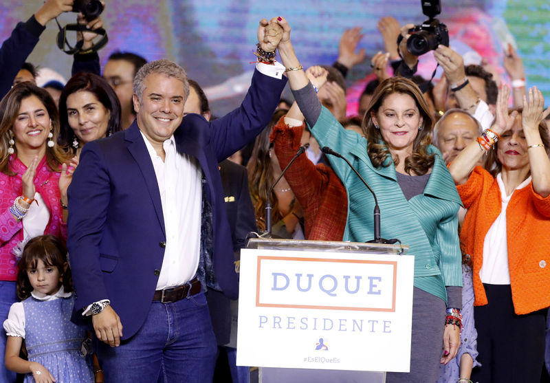 © Reuters. El candidato vencedor de la elección en Colombia, el derechista Iván Duque, levanta la mano de su compañera de fórmula y vicepresidente electa Marta Lucía Ramírez, en un acto con partidarios en Bogota tras su triunfo.