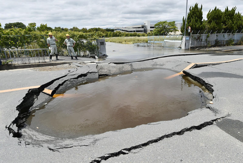 © Reuters. A water-filled crack on a road after water pipes were broken due to an earthquake is seen in Takatsuki