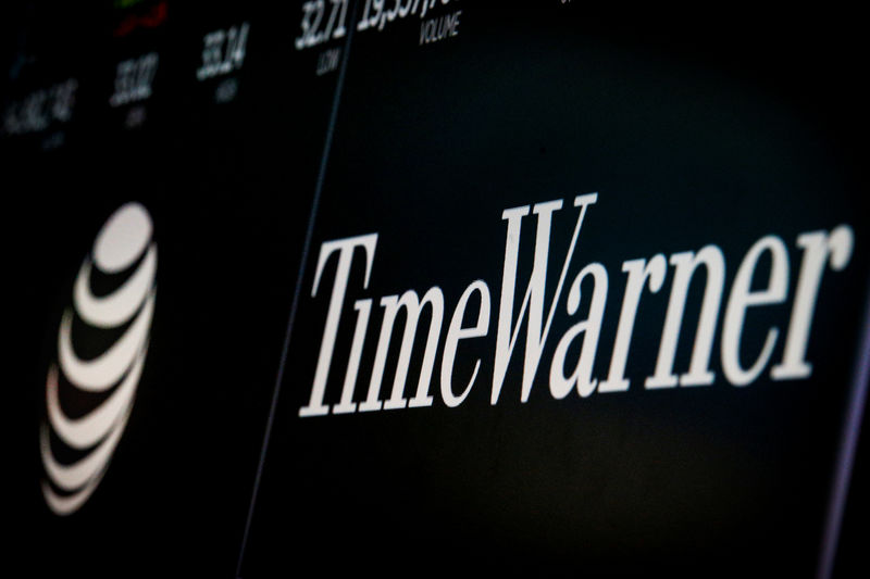 © Reuters. Logos and trading information for AT&T and Time Warner are displayed on a screen on the floor of the NYSE in New York