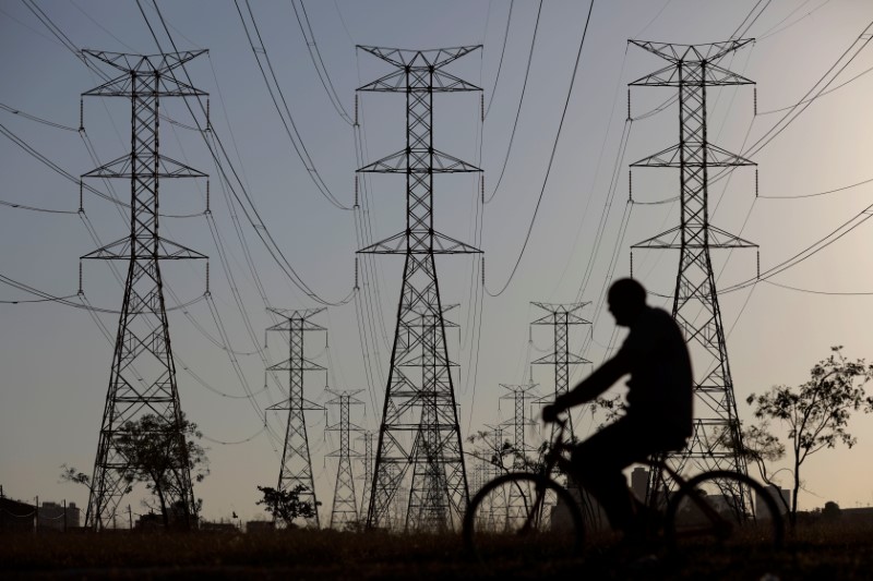 © Reuters. Homem passa de bicicleta por torres de energia em Brasília, Brasil