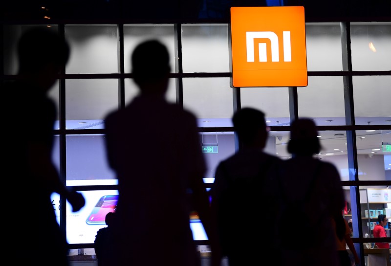 © Reuters. People walk past a Xiaomi store in Shenyang