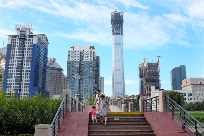 © Reuters. FILE PHOTO: People walk at a park near Beijing's central business area