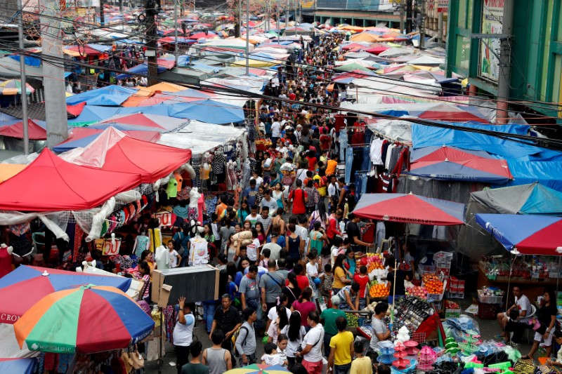 © Reuters. FILE PHOTO - People shop at a street market in Divisoria, Manila
