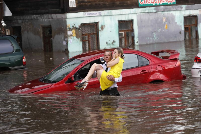 © Reuters. Mulher é resgatada de carro em rua alagada de Nizhny Novgorod