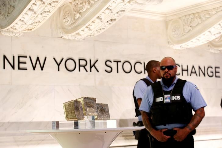 © Reuters. Вооруженные охранники рядом со слитками золота, выставленными на показ на Нью-Йоркской фондовой бирже