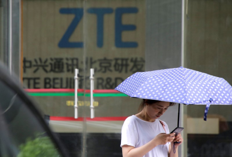 © Reuters. FILE PHOTO: A woman stands outside a building of ZTE Beijing research and development center in Beijing