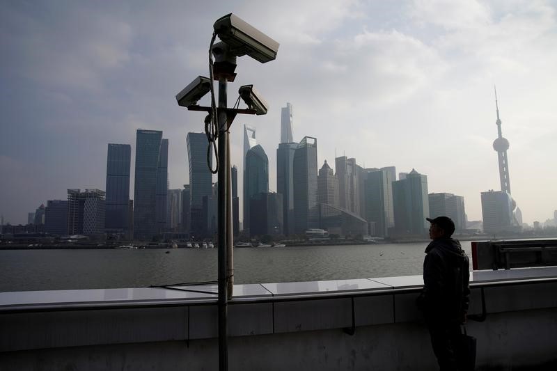 © Reuters. A man stands on the Bund in front of Shanghai's financial district of Pudong in Shanghai