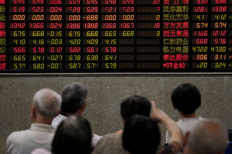 © Reuters. Investors look at an electronic board showing stock information at a brokerage house in Shanghai