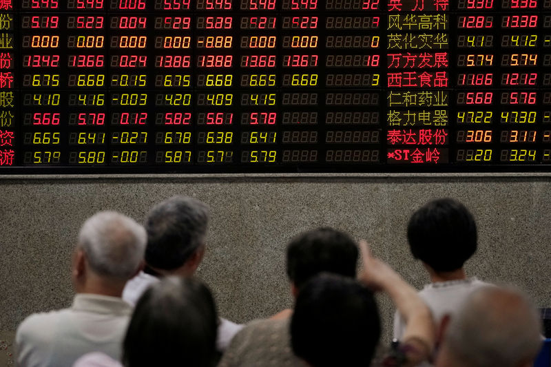 © Reuters. Инвесторы у табло с котировками акций в брокерской фирме в Шанхае