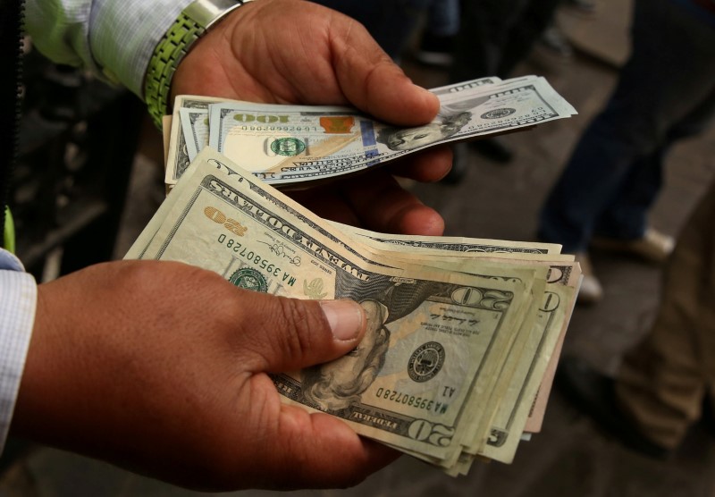 © Reuters. A money changer holds U.S. dollar bills at a street in downtown Lima