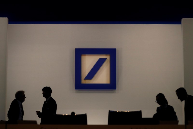 © Reuters. FILE PHOTO: People are silhouetted next to the Deutsche Bank's logo prior to the bank's annual meeting in Frankfurt
