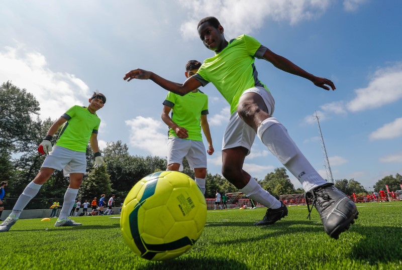 © Reuters. مئات اللاجئين يشاركون في بطولة لكرة القدم في بلجيكا