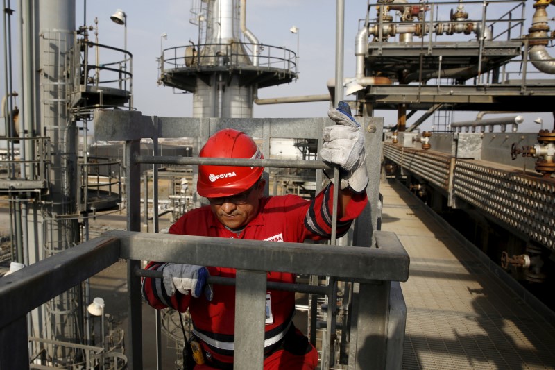 © Reuters. FILE PHOTO: An oilfield worker walks down the stairs, at Jose Antonio Anzoategui industrial complex of oil producer PDVSA in the state of Anzoategui