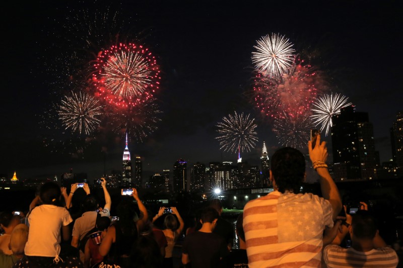 © Reuters. People watch the Macy's 4th of July Firework Show from Brooklyn in New York City