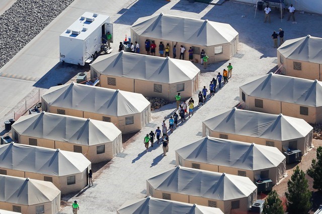 © Reuters. Niños inmigrantes alojados en un campamento de campaña caminan en fila en una instalación cerca de la frontera con México en Tornillo, Texas, Estados Unidos