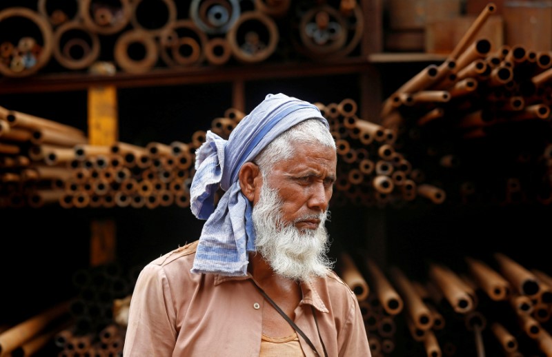 Â© Reuters. FILE PHOTO: A labourer stands in front of a steel pipe storage rack at an industrial area in Mumbai