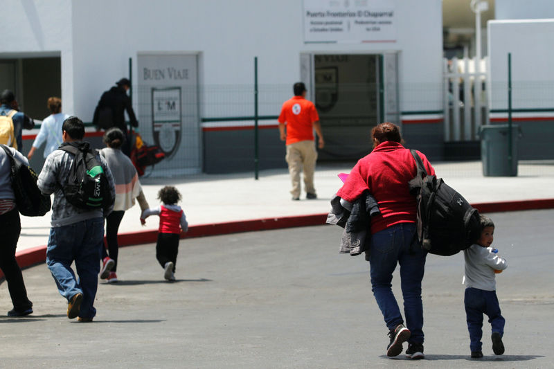© Reuters. Migrants walks to enter the United States border and customs facility to apply for asylum, in Tijuana