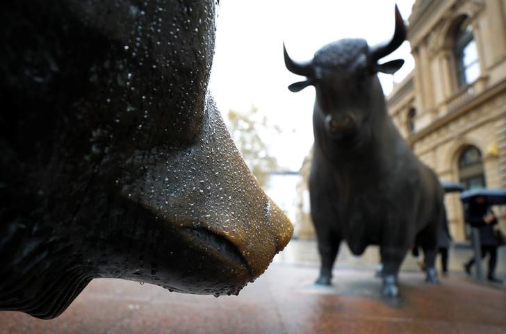 © Reuters. People with umbrellas pass by bull and bear outside Frankfurt's stock exchange during heavy rain in Frankfurt