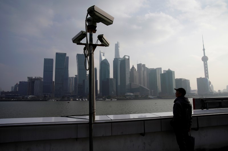 © Reuters. FILE PHOTO -  A man stands on the Bund in front of Shanghai's financial district of Pudong in Shanghai