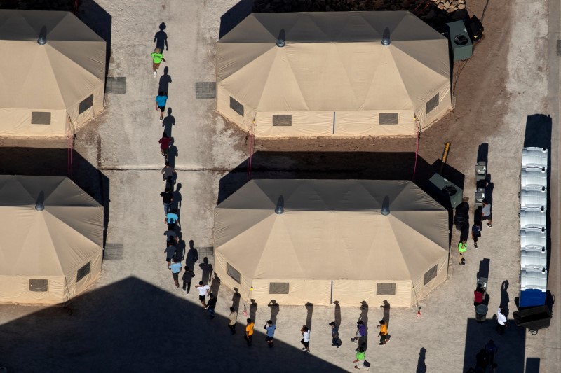 © Reuters. Crianças imigrantes são acompanhadas por funcionários em centro de detenção na fronteira dos Estados Unidos com o México