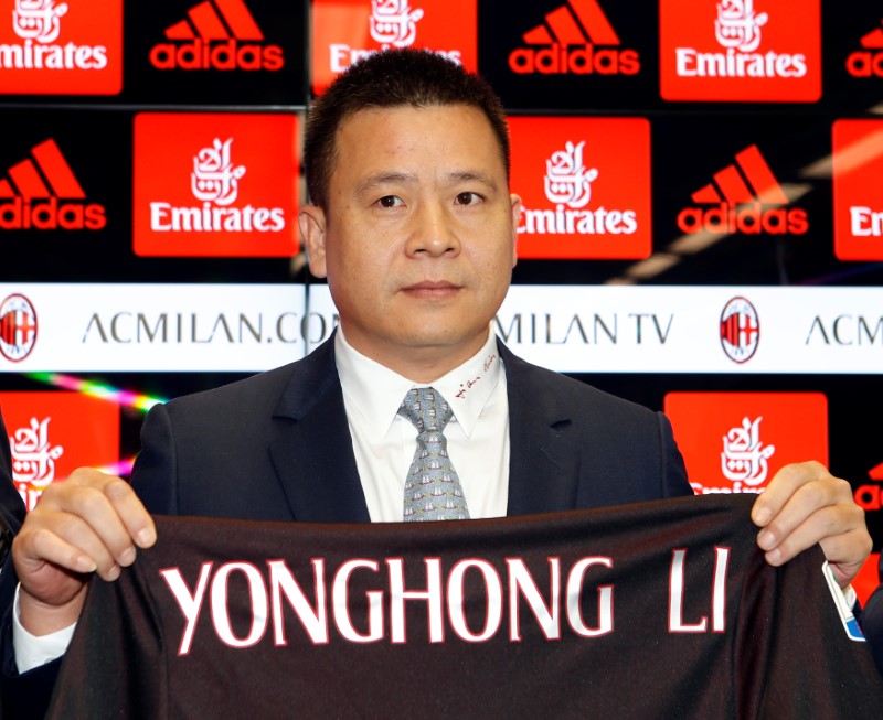 © Reuters. Yonghong Li mostra una maglietta del Milan col suo nome
