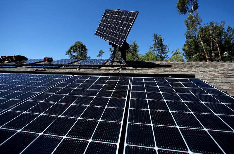 © Reuters. FILE PHOTO: A solar installer from installs a solar panel on the roof of a residential home in Scripps Ranch