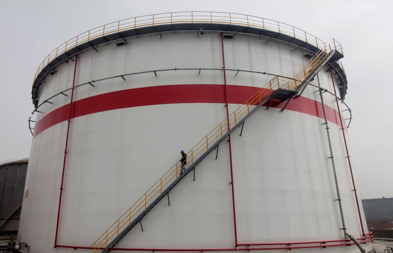 © Reuters. FILE PHOTO: A worker walks down stairs of an oil tank at a refinery in Wuhan