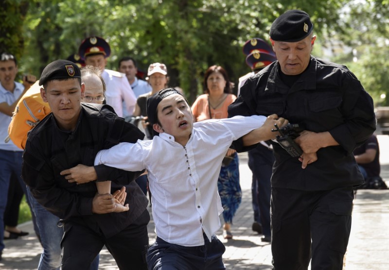 © Reuters. Police officers detain an opposition supporter attempting to stage a protest rally in Almaty