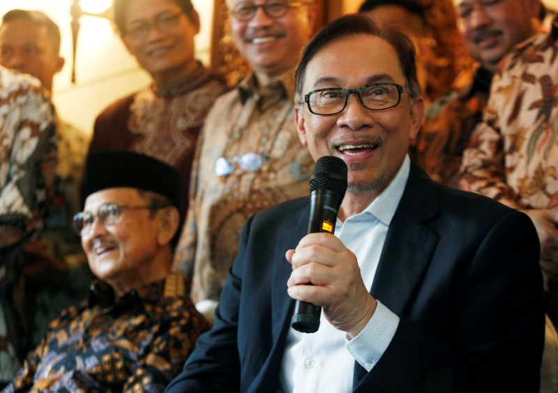 © Reuters. FILE PHOTO: Malaysian politician Anwar Ibrahim speaks with the media as former Indonesian President B.J. Habibie looks on during a visit to Habibie's home in Jakarta
