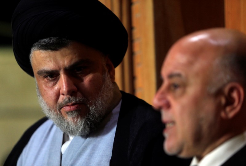 © Reuters. Iraqi Shi'ite cleric Moqtada al-Sadr, who's bloc came first, looks at Iraqi Prime Minister Haider al-Abadi, who's political bloc came third in a May parliamentary election, during a news conference in Najaf