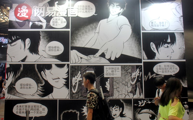 © Reuters. People walk past a booth of NetEase Comics at the CCG Expo in Shanghai