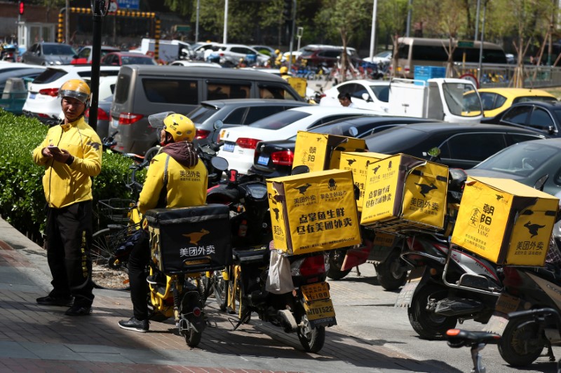 © Reuters. Drivers of food delivery service Meituan are seen in Beijing