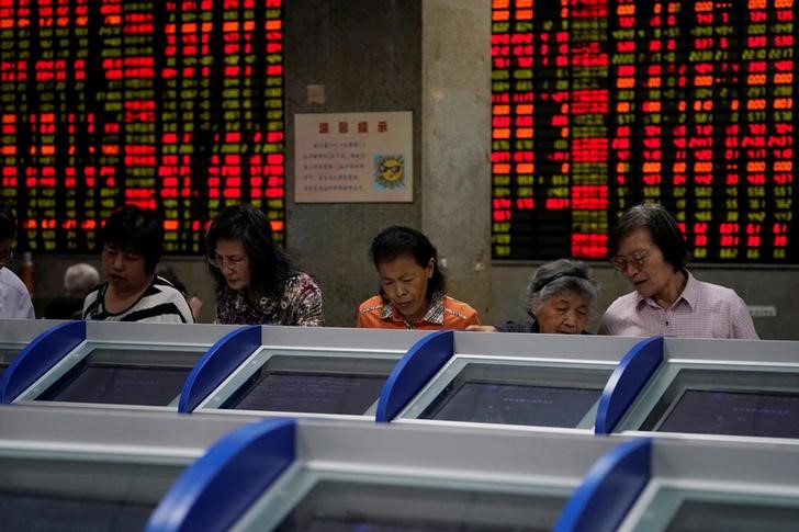 © Reuters. Инвесторы следят за котировками акций на экранах компьютеров в брокерской фирме в Шанхае