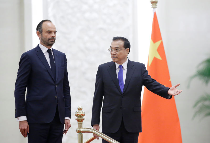 © Reuters. French Prime Minister Edouard Philippe and China's Premier Li Keqiang attend a welcome ceremony in Beijing