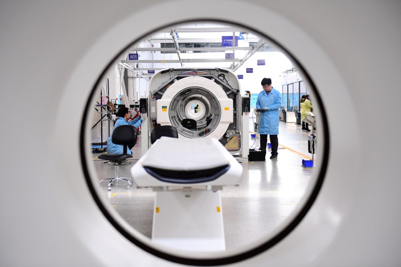 © Reuters. FILE PHOTO: Employees work to assemble computed tomography (CT) scanners at a production line of a company manufacturing medical equipment in Shenyang